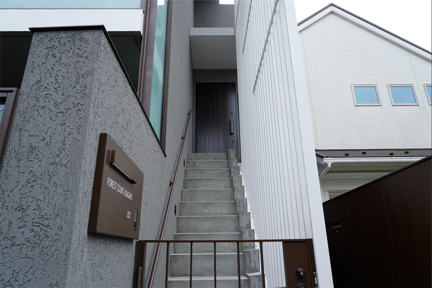 白の鉄格子が創る光と影を感じて昇る2F玄関アプローチ階段